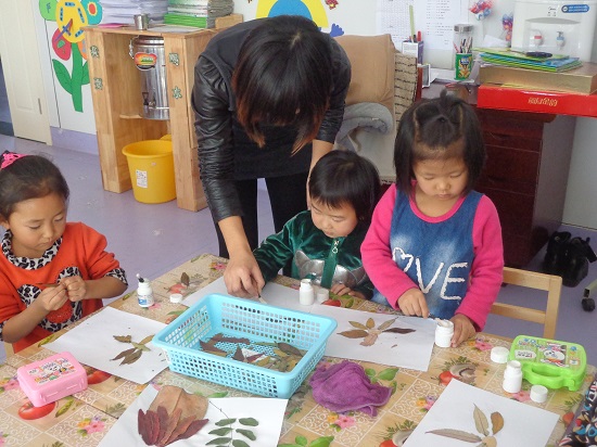 班幼儿在做树叶粘贴画-静海县团泊镇第一幼儿园
